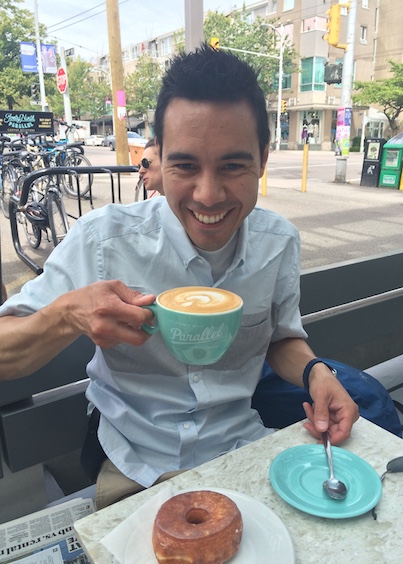 Réjean qui boit un café au lait et mange un beigne